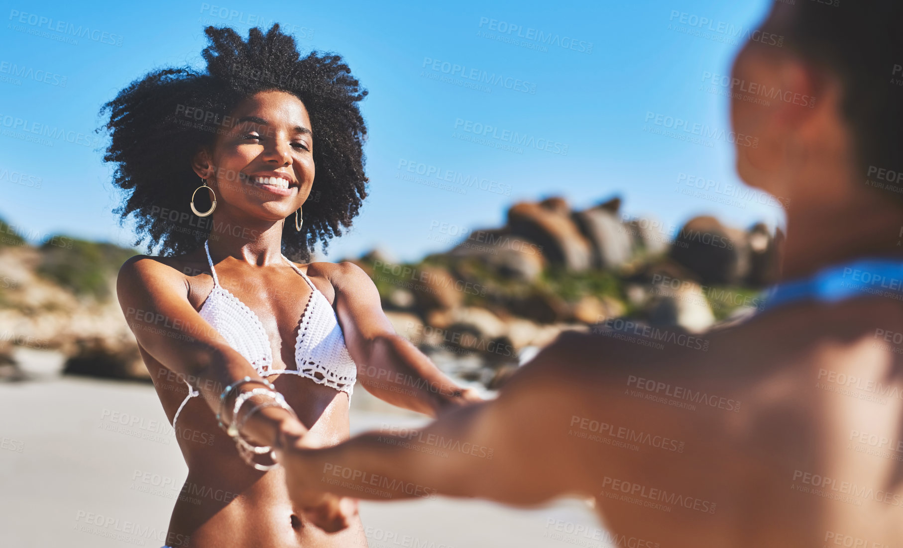 Buy stock photo Shot of two young women enjoying a playful moment on the beach