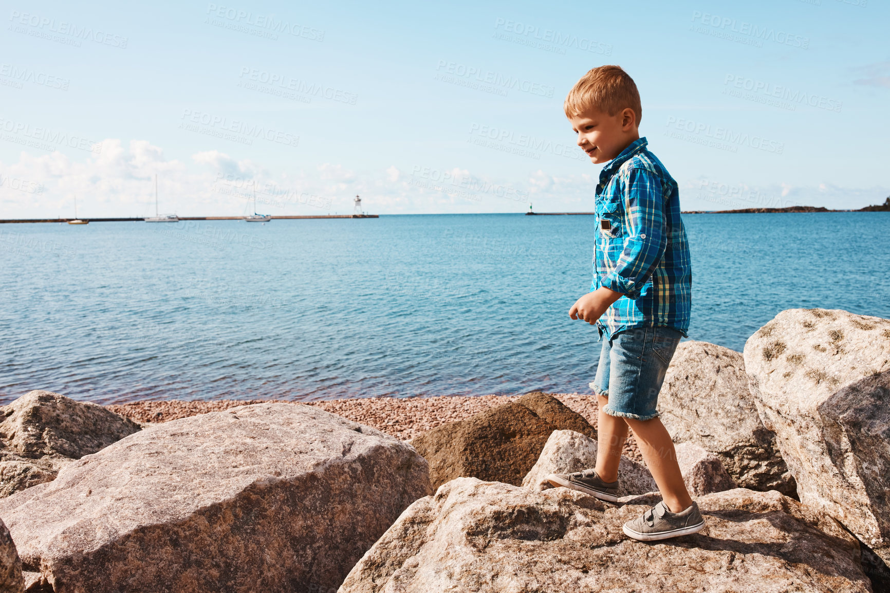 Buy stock photo Shot of an adorable little boy playing on the rocks