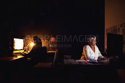 Buy stock photo Shot of two businesswomen working late in an office