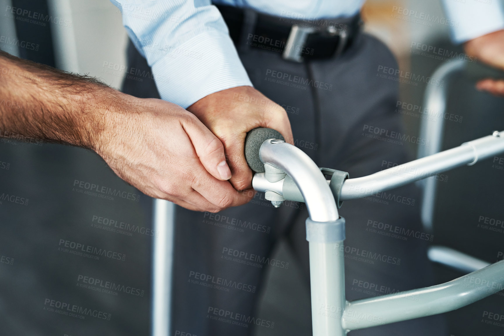 Buy stock photo Closeup shot of a person assisting a man with a walker