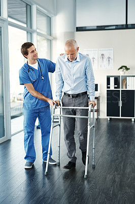 Buy stock photo Shot of a male nurse assisting a senior patient with a walker