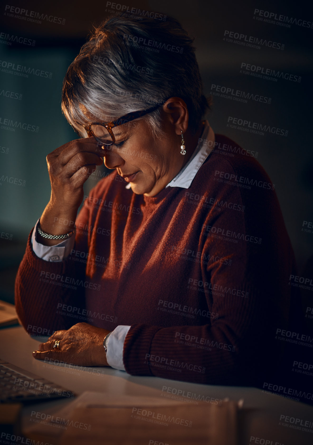 Buy stock photo Shot of a mature businesswoman looking stressed out while working late in an office