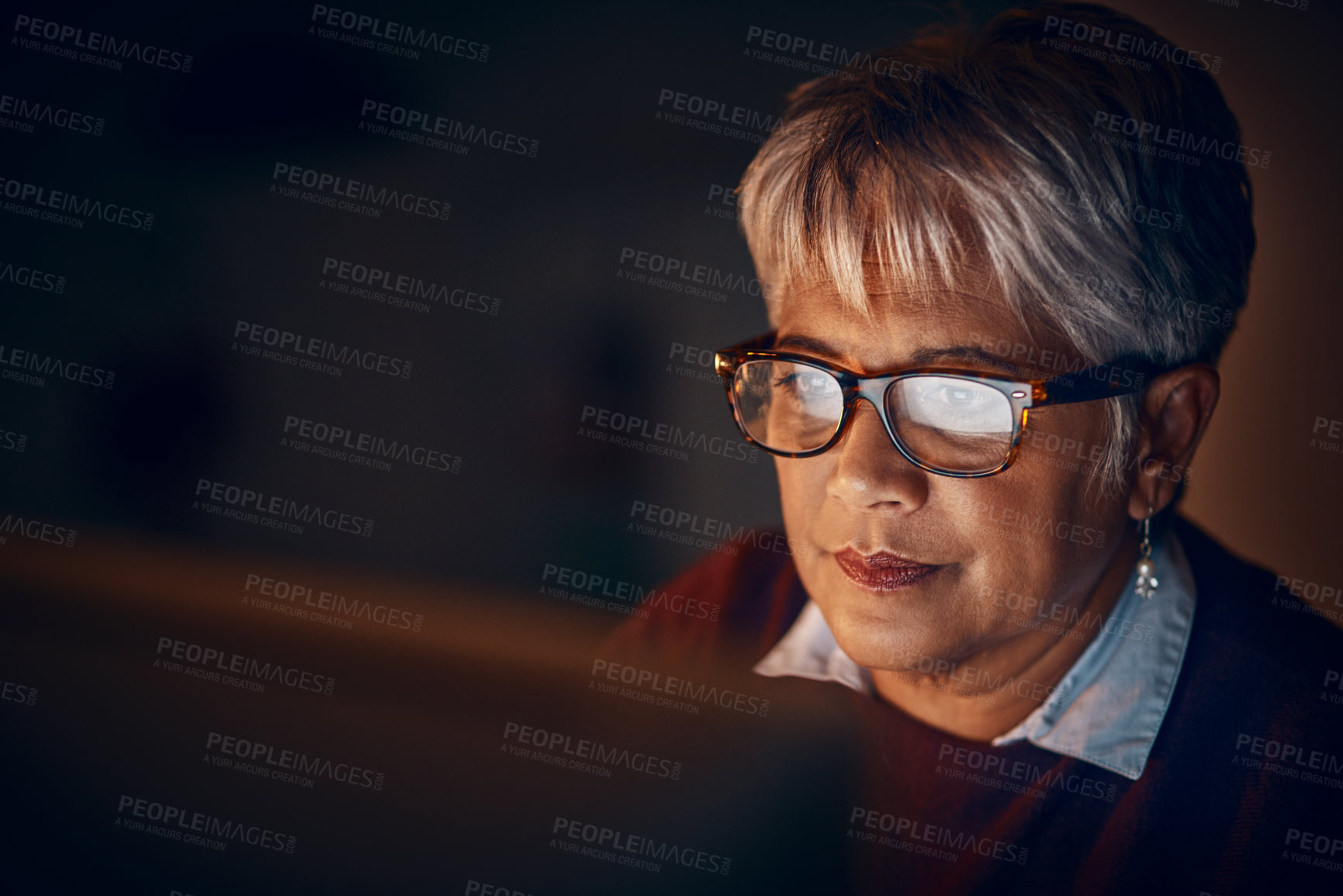 Buy stock photo Shot of a mature businesswoman working late in an office