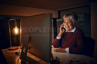 Buy stock photo Night, mature woman and phone call at computer for business, talk o rcontact in office. Dark, happy or lady at desk with tech, scheduling or chatting on mobile for funny story or gossip on late shift