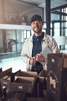 Buy stock photo Portrait of a cheerful young man packing boxes on top of each other inside of a office building during the day