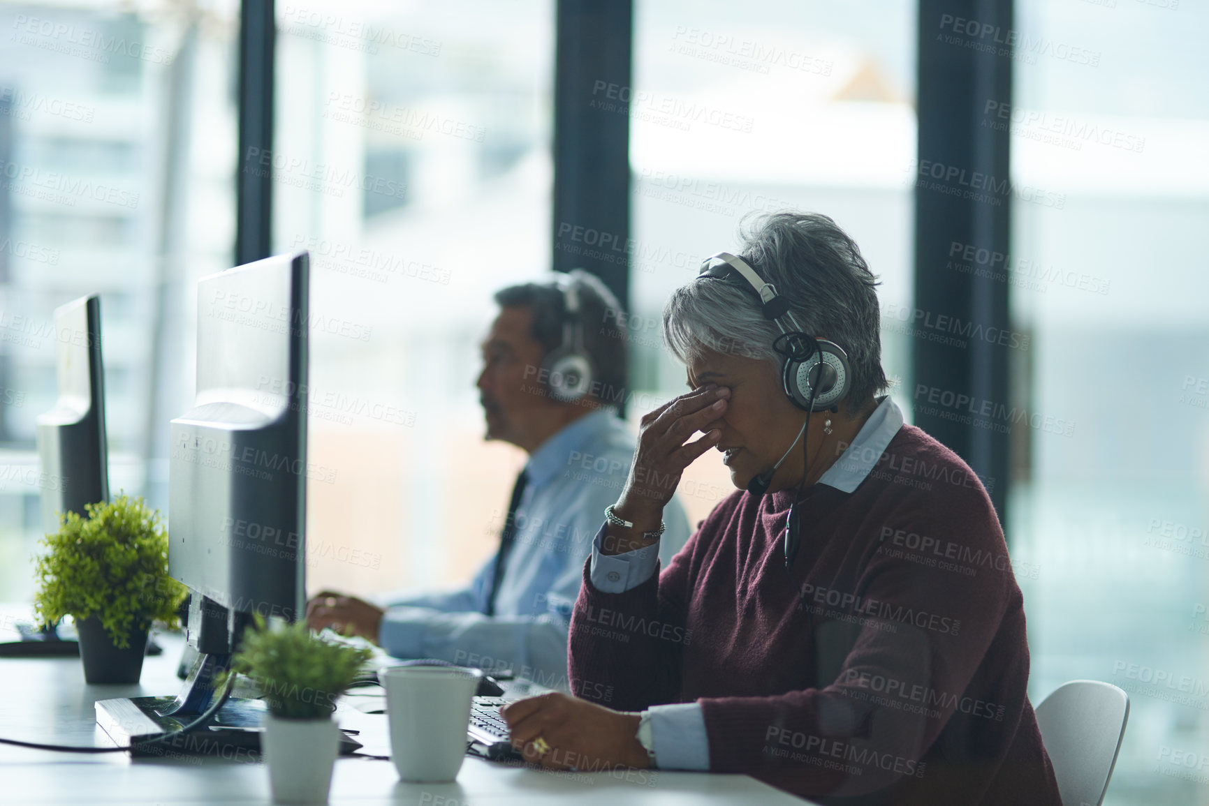 Buy stock photo Woman, call center and office in computer with headache, tired and consulting with client. Mature agent, headphones and mic with fatigue for tech support, telemarketing or customer care with burnout