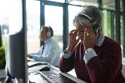 Buy stock photo Woman, call center and stress by computer with headache, tired and consulting with client. Senior agent, headphones and mic with fatigue for tech support, telemarketing or customer care with burnout