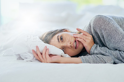 Buy stock photo Portrait of an attractive young woman lying bed while smiling brightly at home during the day