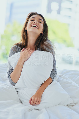Buy stock photo Shot of an attractive young woman seated on her bed while  hugging her pillow with her eyes closed at home during the day