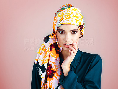 Buy stock photo Studio portrait of a confident young woman wearing a colorful head scarf while posing against a pink background