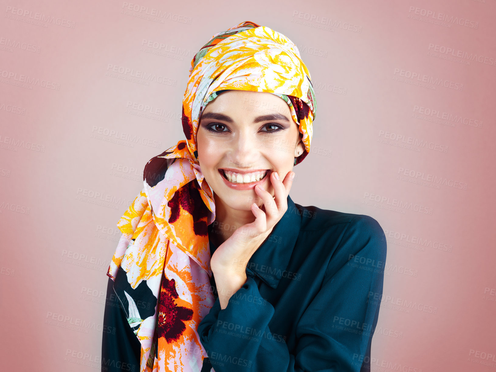 Buy stock photo Studio portrait of a cheerful young woman wearing a colorful head scarf while posing against a pink background