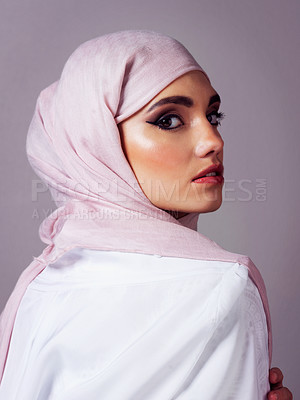 Buy stock photo Studio portrait of a cheerful young woman wearing a colorful head scarf while posing against a grey background