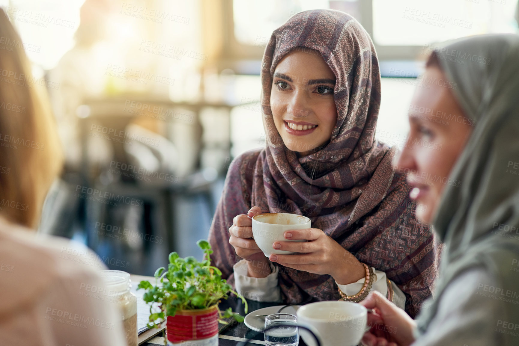 Buy stock photo Friends, smile and Muslim women in coffee shop, bonding and talking together. Cafe, happy and Islamic girls, group or people chatting, conversation and discussion for social meeting in restaurant.