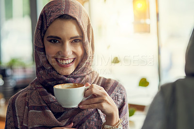 Buy stock photo Shot of a young woman having a coffee with her friend in a cafe