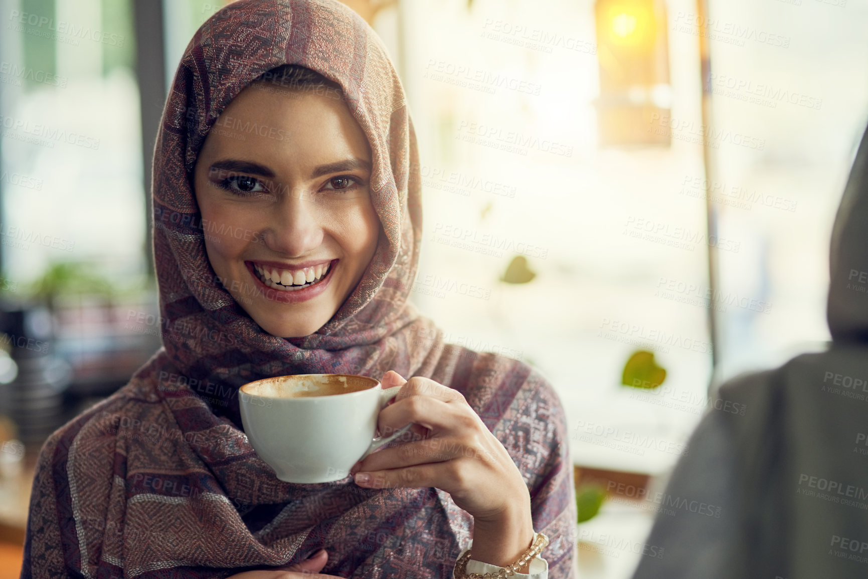 Buy stock photo Shot of a young woman having a coffee with her friend in a cafe