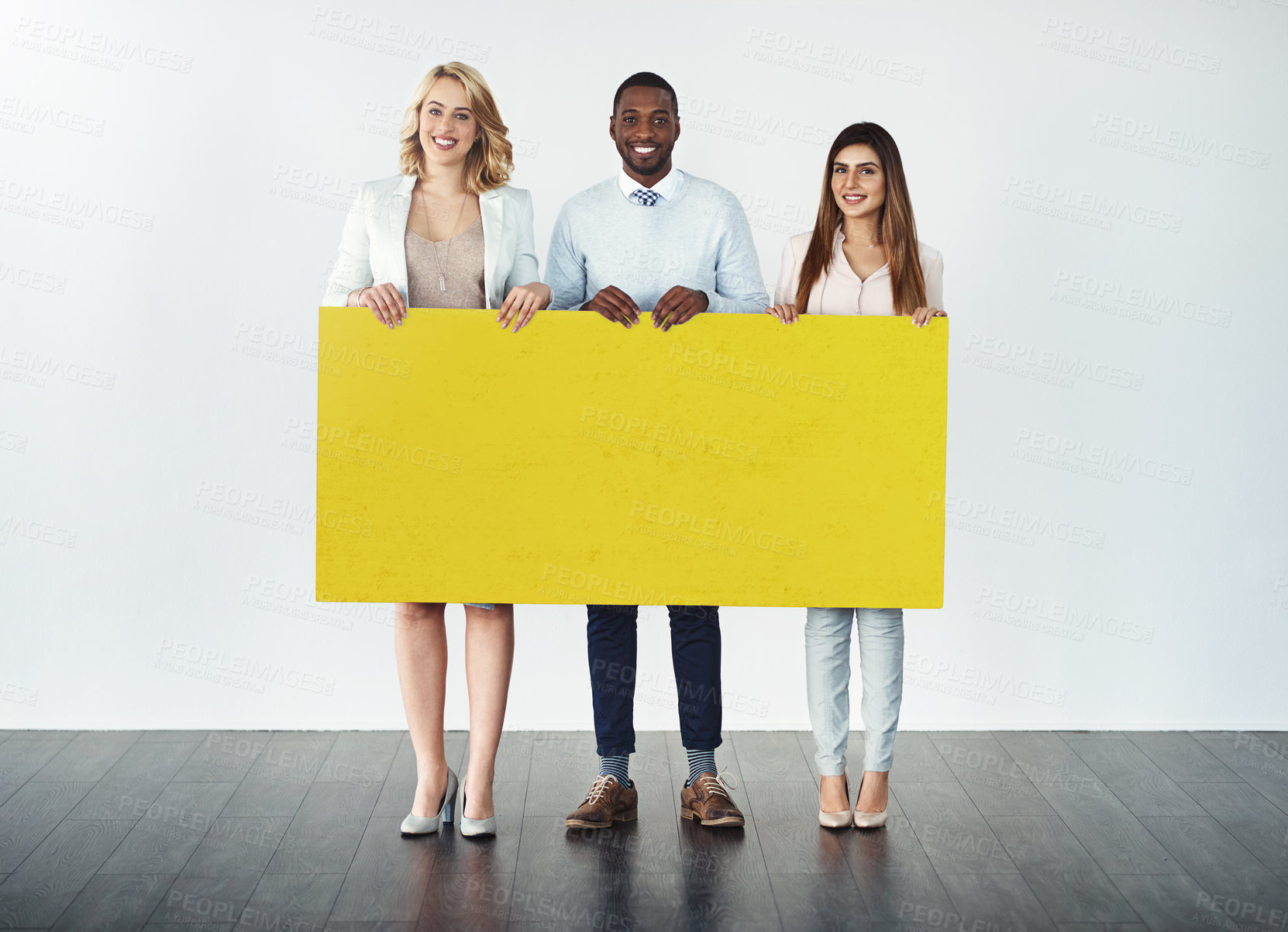 Buy stock photo Studio shot of a group of businesspeople holding up a blank yellow placard