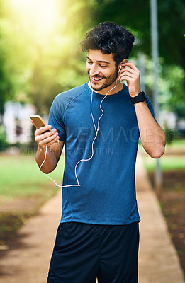 Buy stock photo Earphones, fitness and man with smartphone, park and happiness with motivational podcast. Smile, person and athlete with cellphone, radio and online for audio, streaming music and outdoor for workout