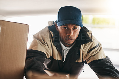 Buy stock photo Shot of a courier sorting boxes in a delivery van