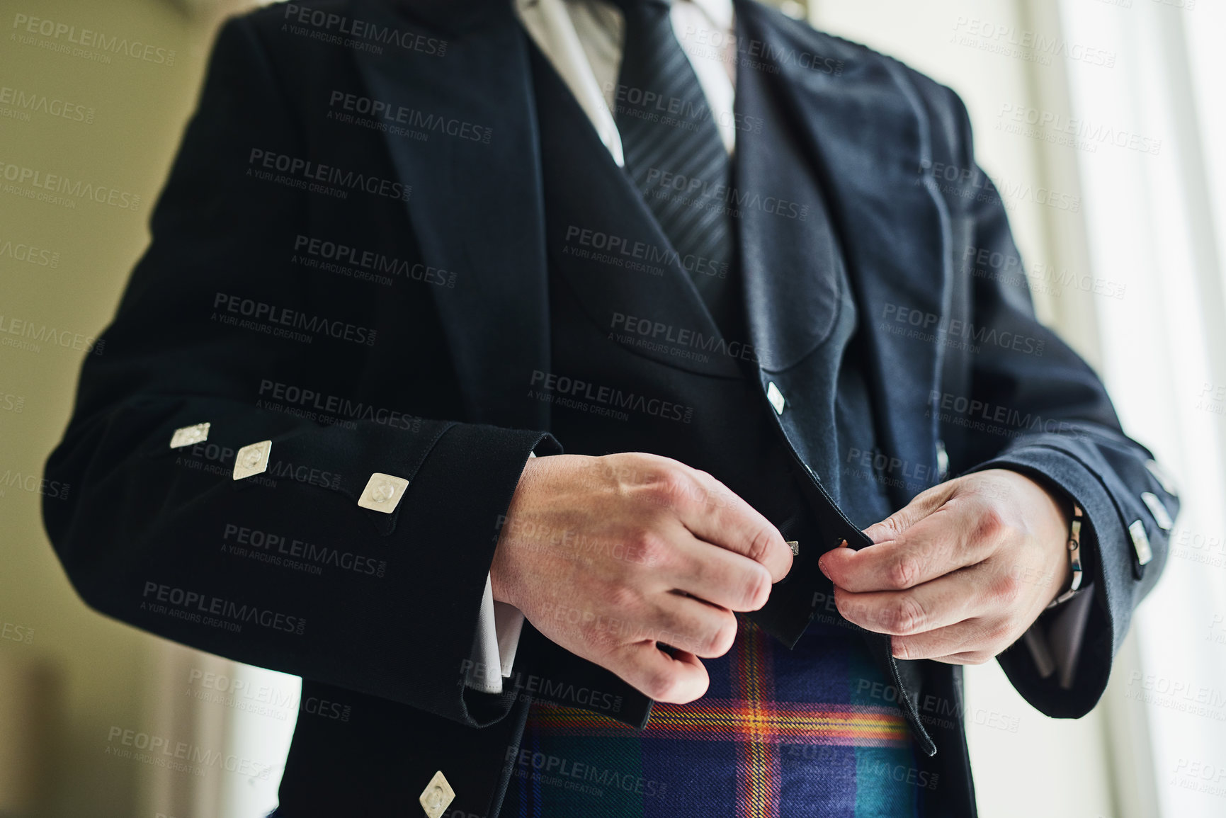 Buy stock photo Shot of an unrecognizable man putting on a suit jacket to get ready for a wedding inside of a building during the day