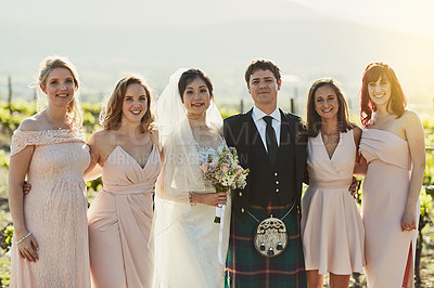 Buy stock photo Portrait of a cheerful bride and groom standing together with the bride's maids arm in arm outside