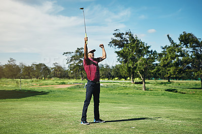 Buy stock photo Shot of a cheerful young male golfer lifting up his hands in success of playing a good shot outside during the day