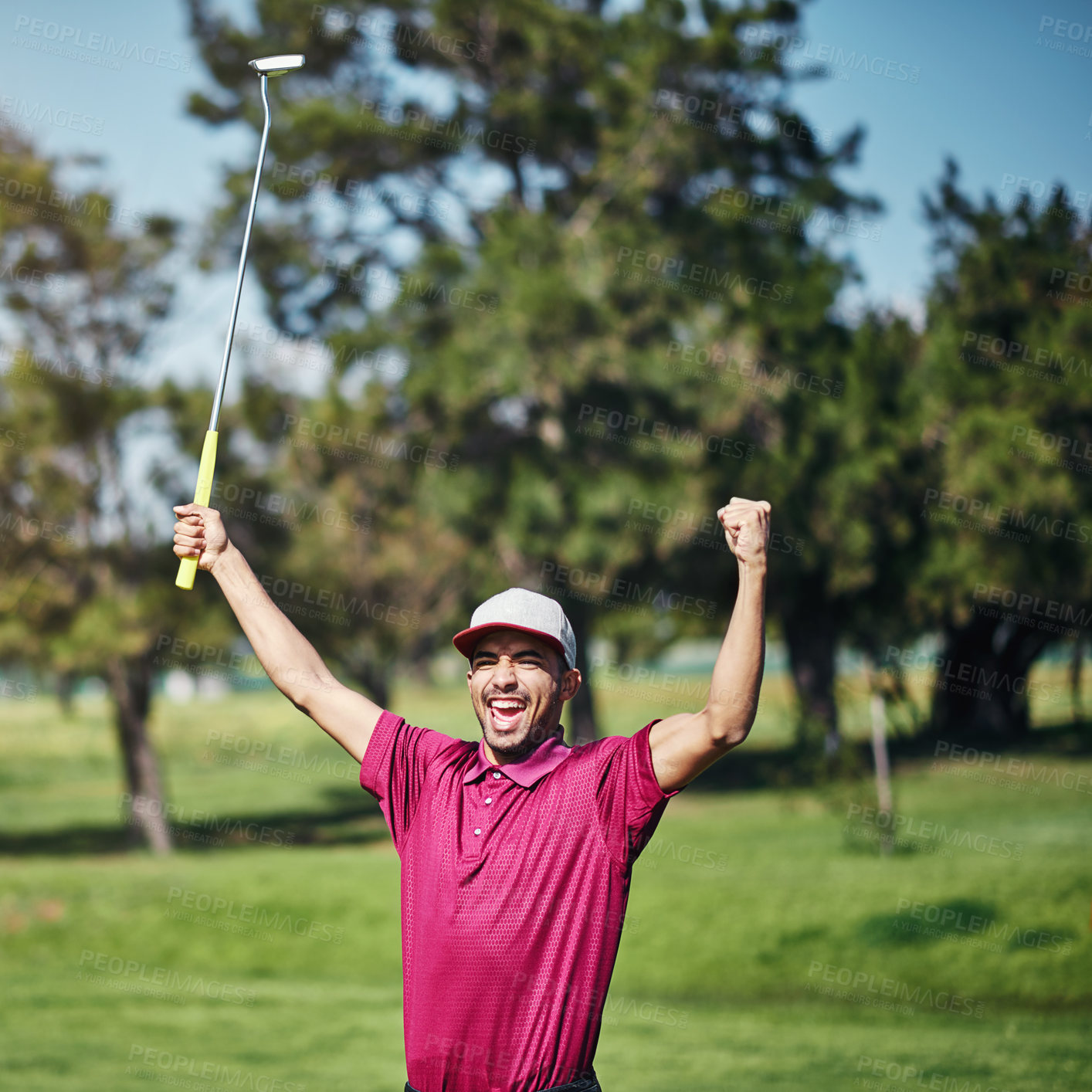 Buy stock photo Shot of a cheerful young male golfer lifting up his hands in success of playing a good shot outside during the day