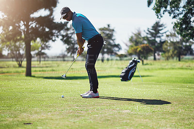 Buy stock photo Shot of a focused young male golfer about to swing and play a shot with his golf club outside on a course