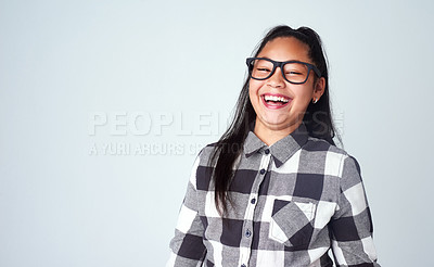 Buy stock photo Portrait, girl and kid with glasses, funny and confidence with humor on blue studio background. Face, happy person and model with smile and eyewear for clear vision, laugh and mockup space with joke