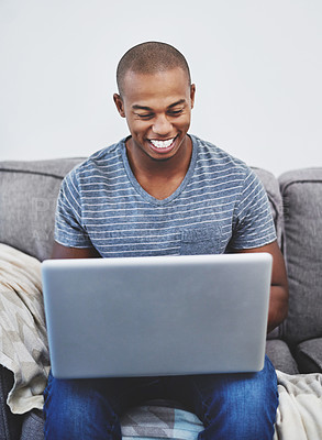 Buy stock photo Shot of a handsome young man using a laptop at home