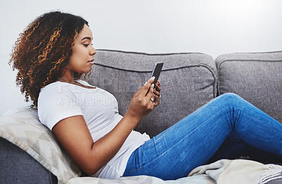 Buy stock photo Shot of an attractive young woman using a digital tablet at home