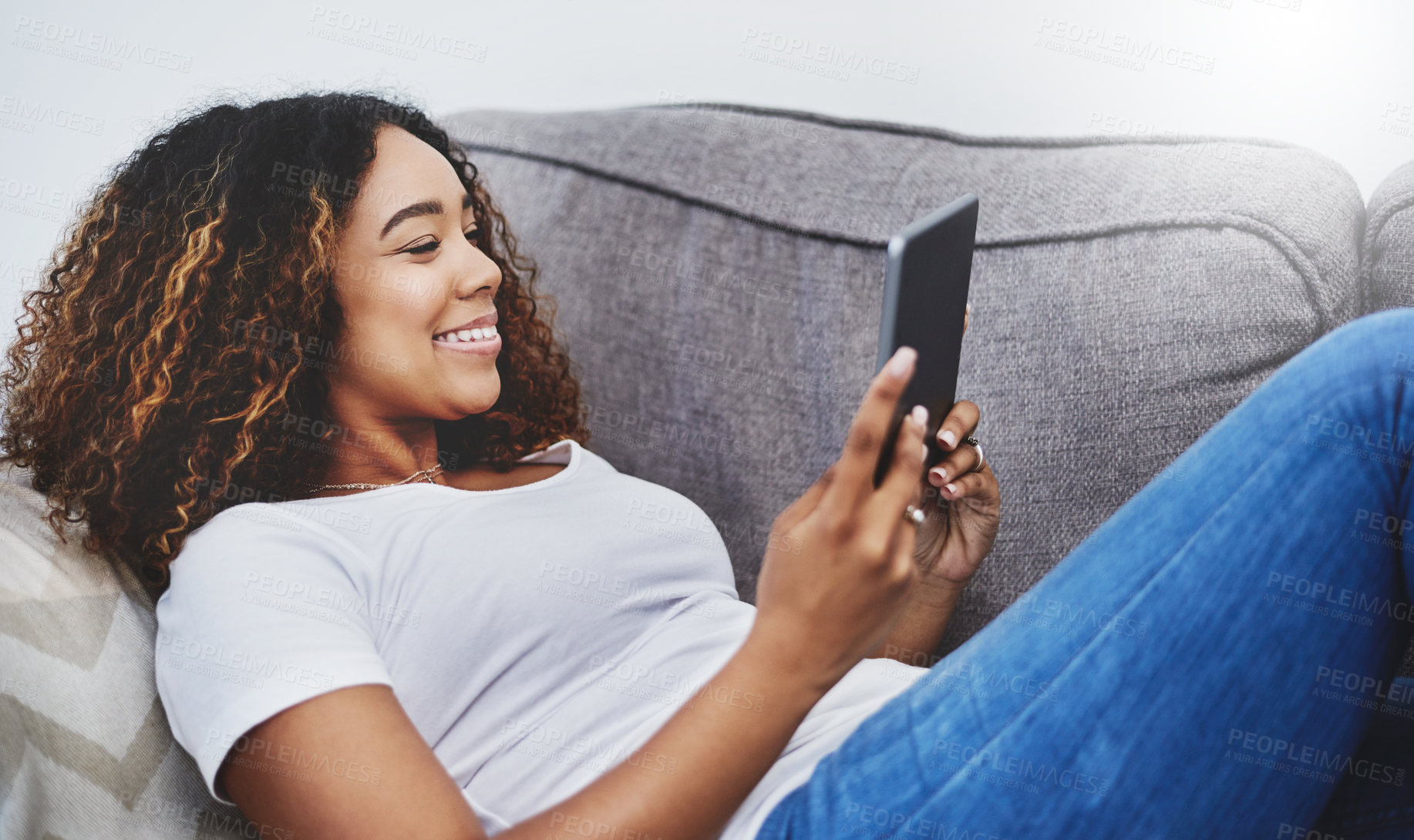 Buy stock photo Shot of an attractive young woman using a digital tablet at home