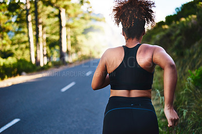 Buy stock photo Rearview shot of a young woman out for her morning run