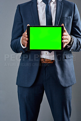 Buy stock photo Studio shot of an unrecognizable corporate businessman holding a tablet against a grey background