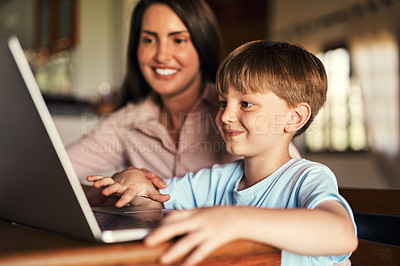Buy stock photo Shot of an adorable little boy using a laptop with his mother at home