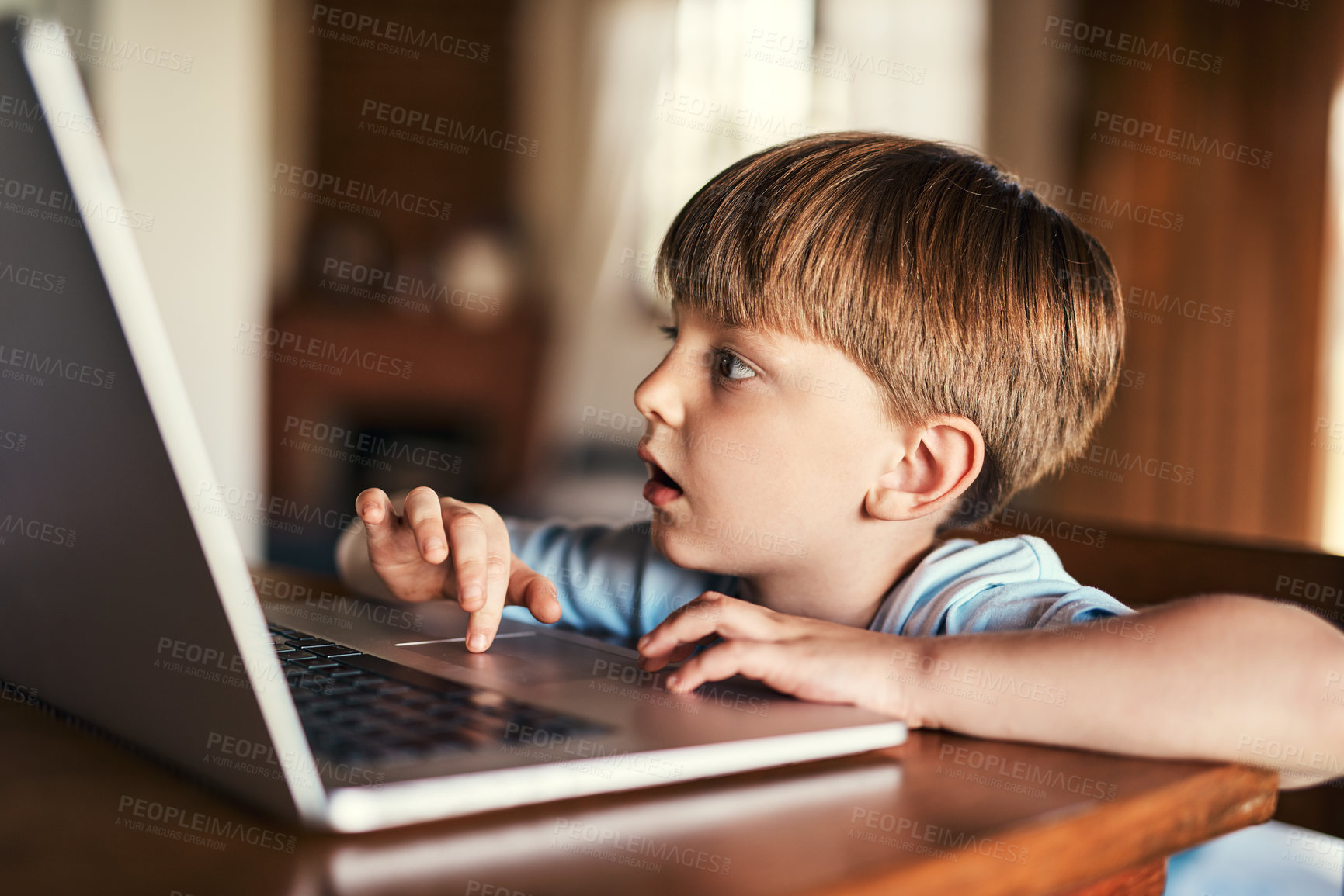 Buy stock photo Shot of an adorable little boy using a laptop at home