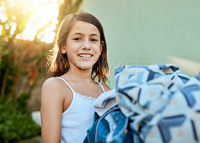 Buy stock photo Portrait of a little girl hanging up laundry outside