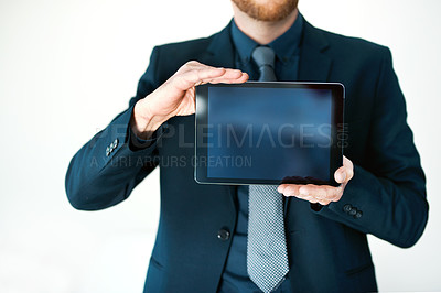 Buy stock photo Cropped shot of an unrecognizable businessman holding up a digital tablet