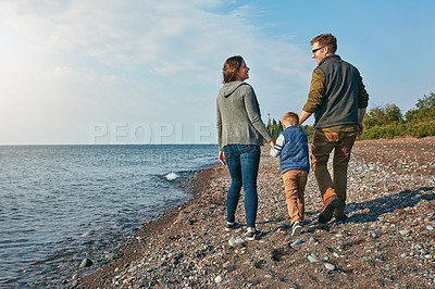 Buy stock photo Rearview shot of a young family walking by the lake