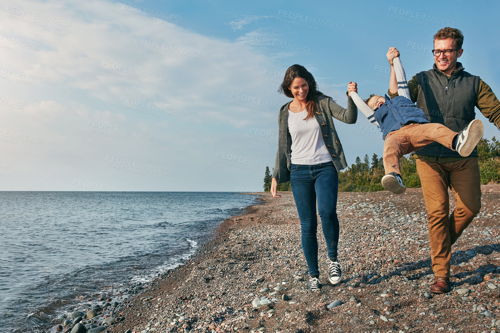 Buy stock photo Shot of a young family spending a day at the lake