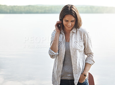 Buy stock photo Shot of an attractive young woman relaxing at the lake