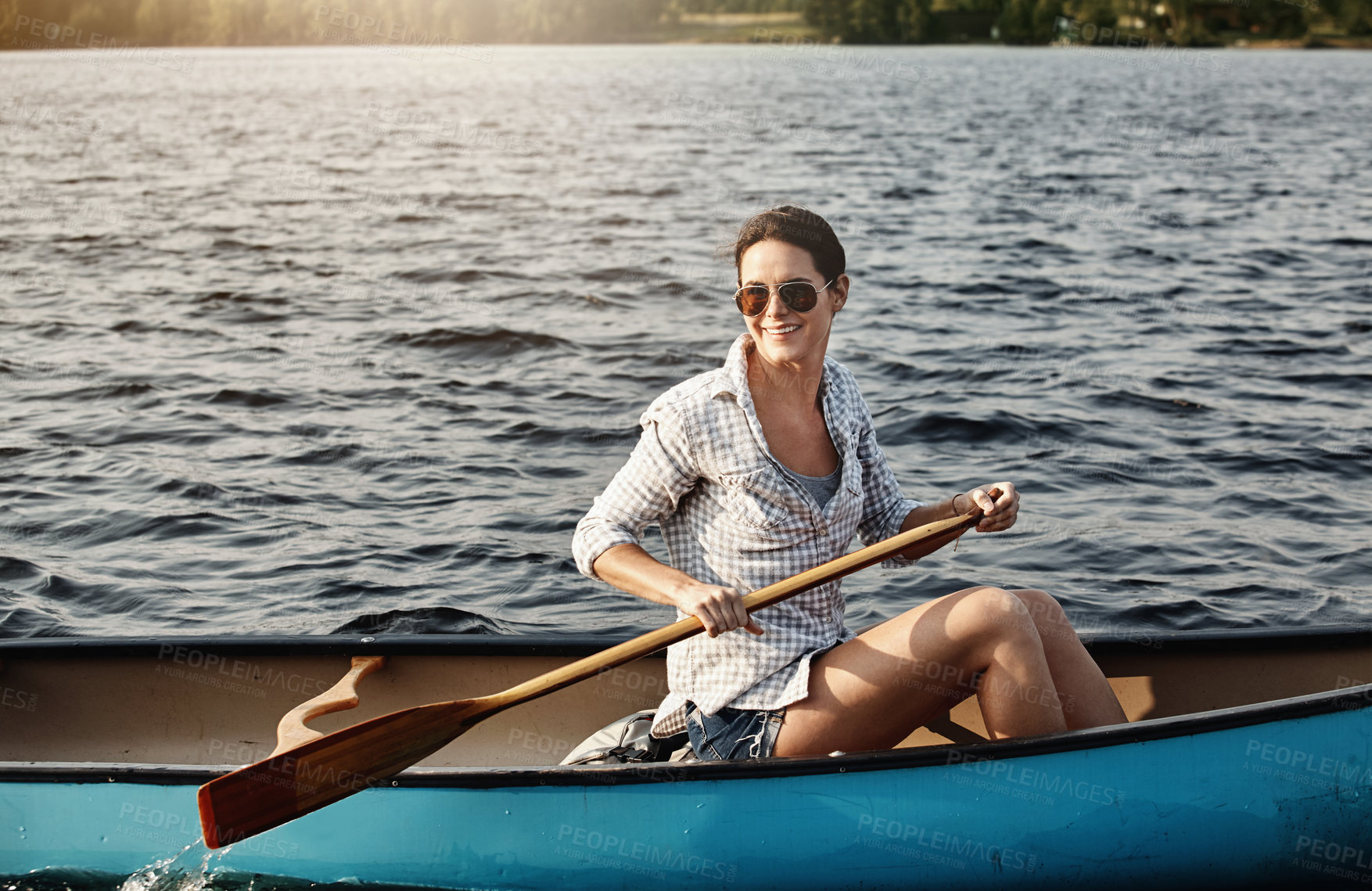 Buy stock photo Shot of an attractive young woman out for canoe ride on the lake
