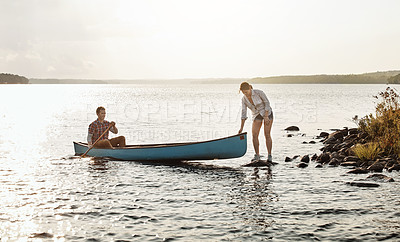 Buy stock photo Shot of a young couple going for a canoe ride on the lake