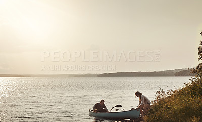 Buy stock photo Shot of a young couple going for a canoe ride on the lake