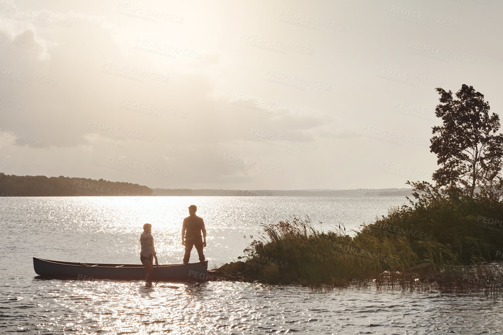 Buy stock photo Shot of a young couple going for a canoe ride on the lake