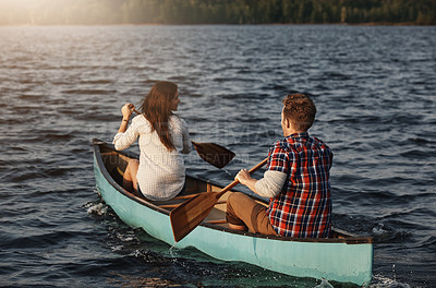 Buy stock photo Rearview shot of an unrecognizable couple rowing a boat out on the lake