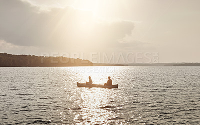 Buy stock photo Shot of an unrecognizable couple rowing a boat out on the lake