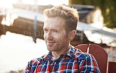 Buy stock photo Shot of a handsome young man relaxing on a deck chair outdoors