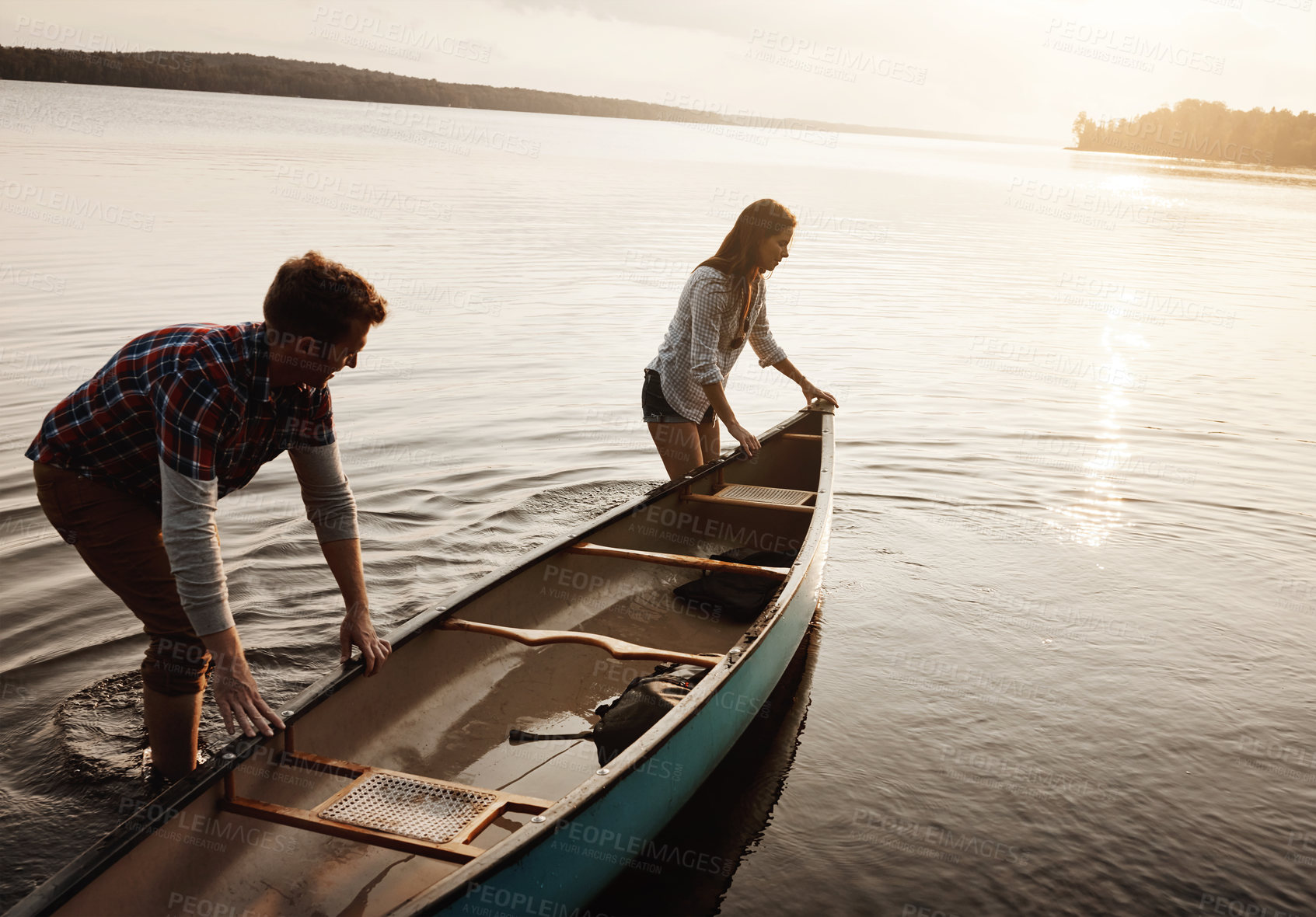 Buy stock photo Boat, adventure and man with woman by lake for travel, summer and sunset in nature. Friend or couple and sunshine for happiness, together and freedom or support for canoe and peace by river or creek 