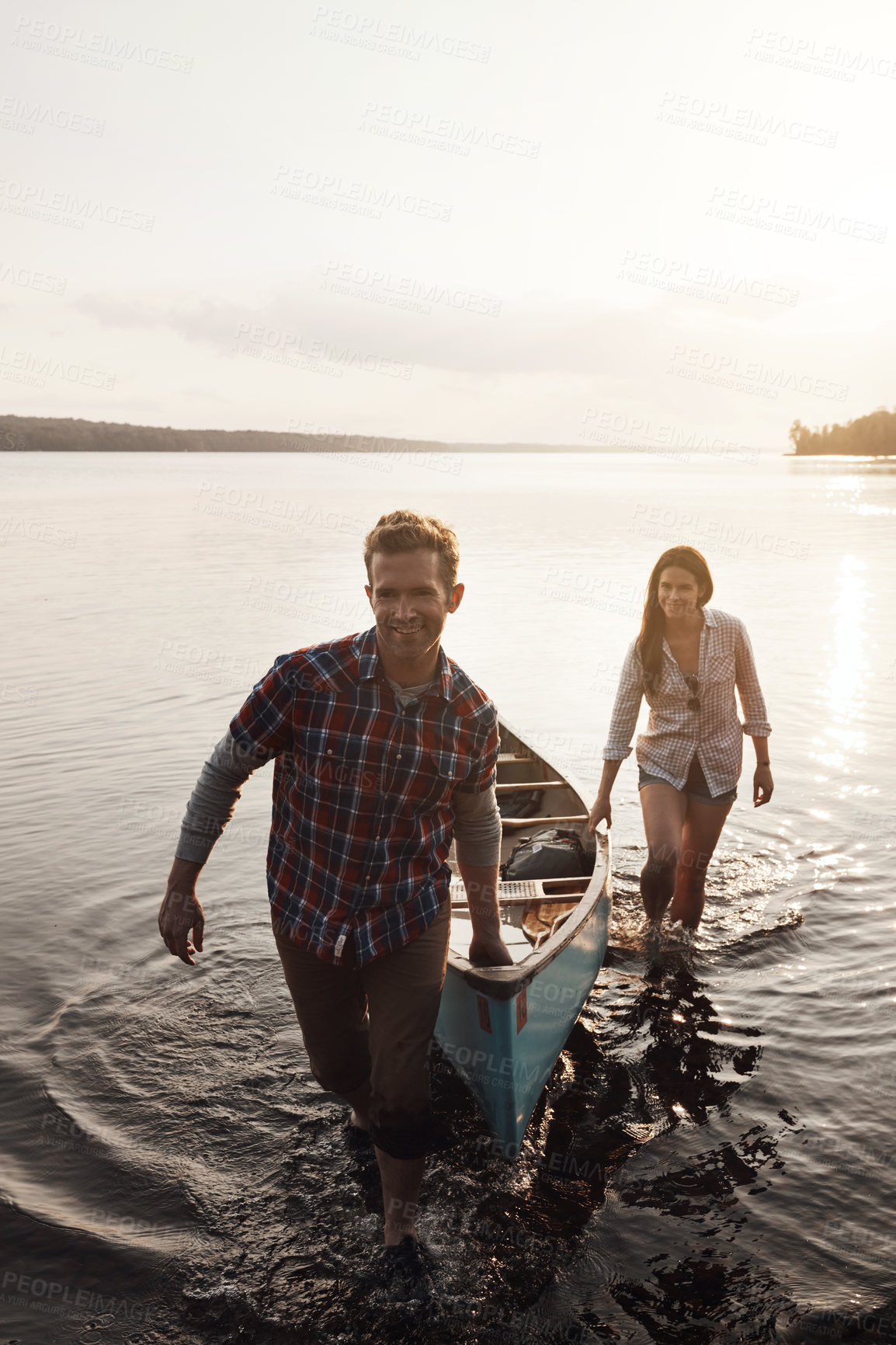 Buy stock photo Happy, adventure and couple with boat by lake for summer, sunset and together in nature. Man, woman and sunshine or smile for travel, freedom and support for canoe and wellness by river for holiday 