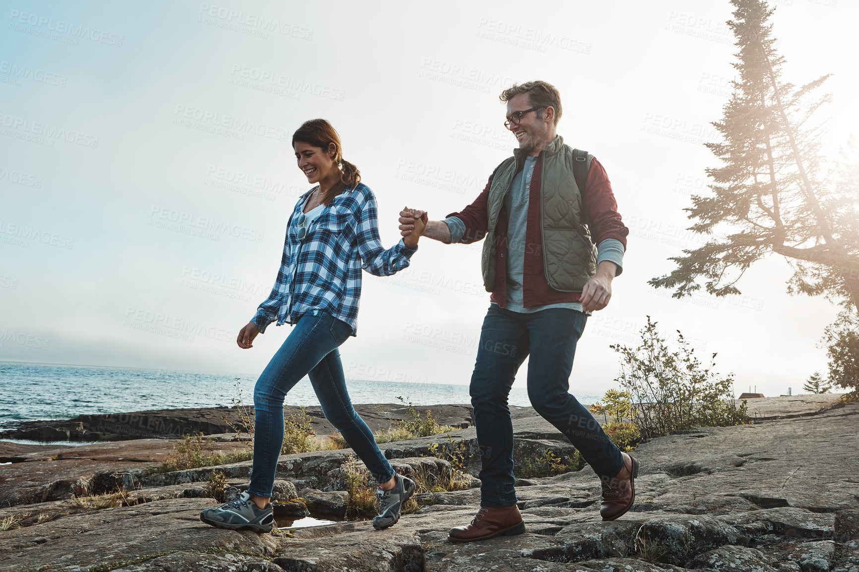 Buy stock photo Shot of a happy couple out hiking hand in hand